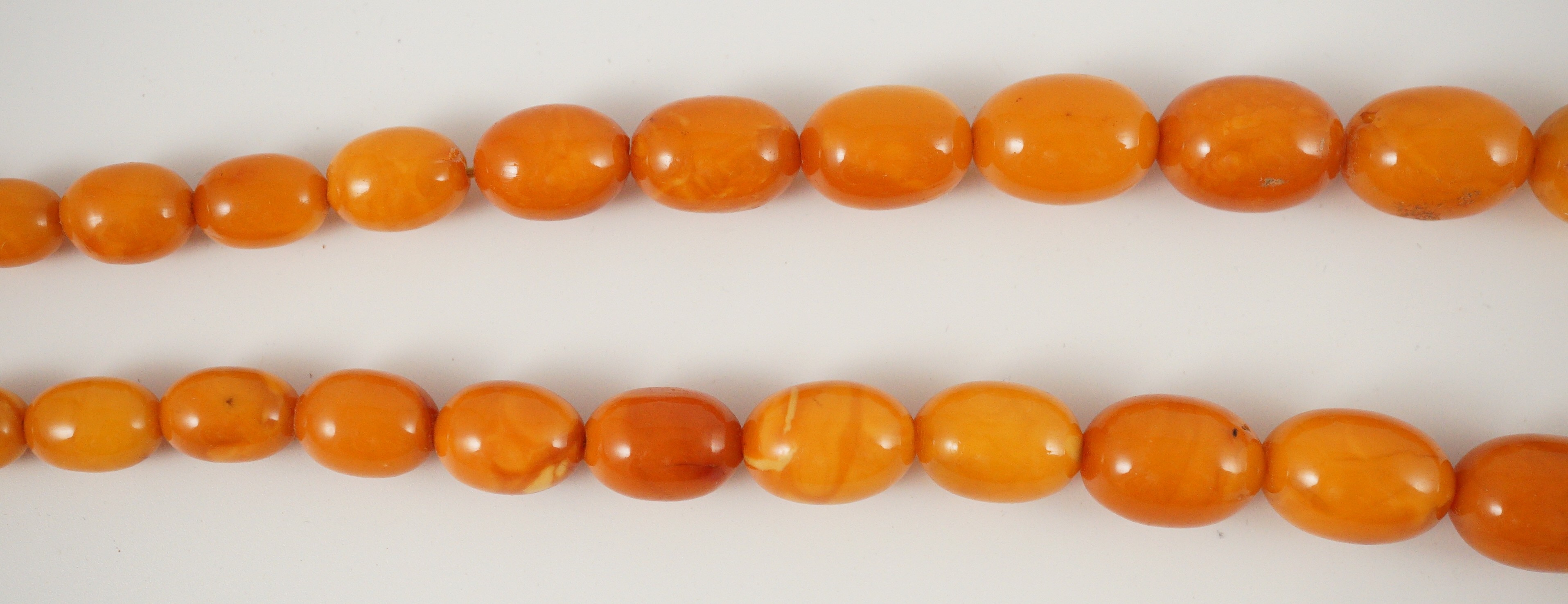 A single stand graduated oval amber bead necklace, 76cm, gross weight 85 grams.